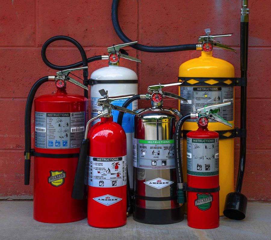 Group of fire extinguishers including ABC dry chemical, CO2, water mist, stainless steel water, and Class D dry powder types